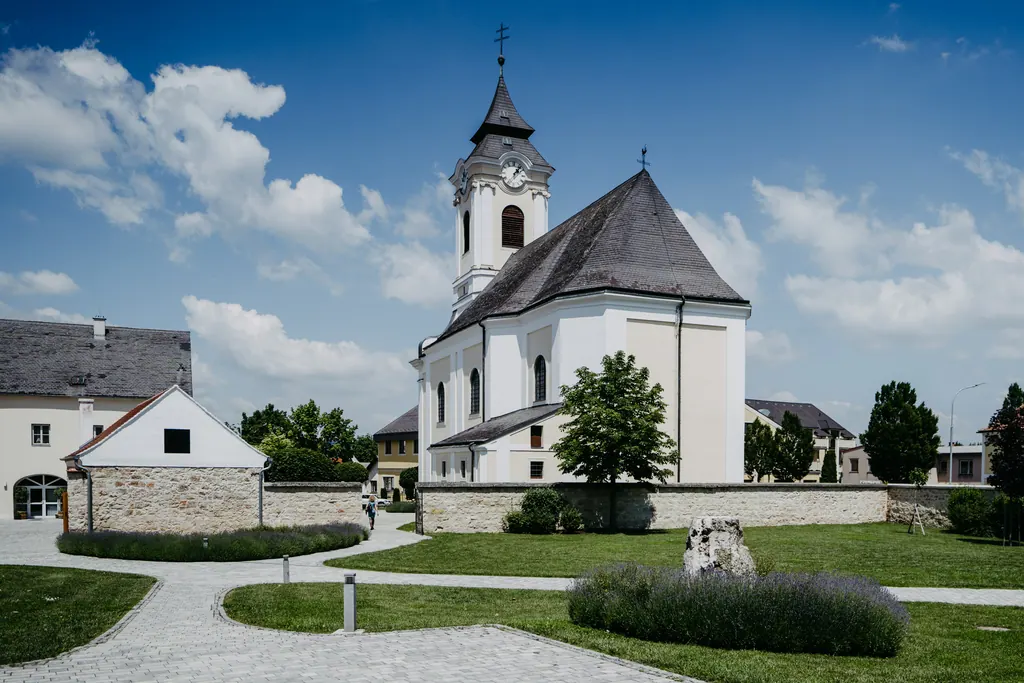 Weiße Dorfkirche mit Turm unter blauem Himmel