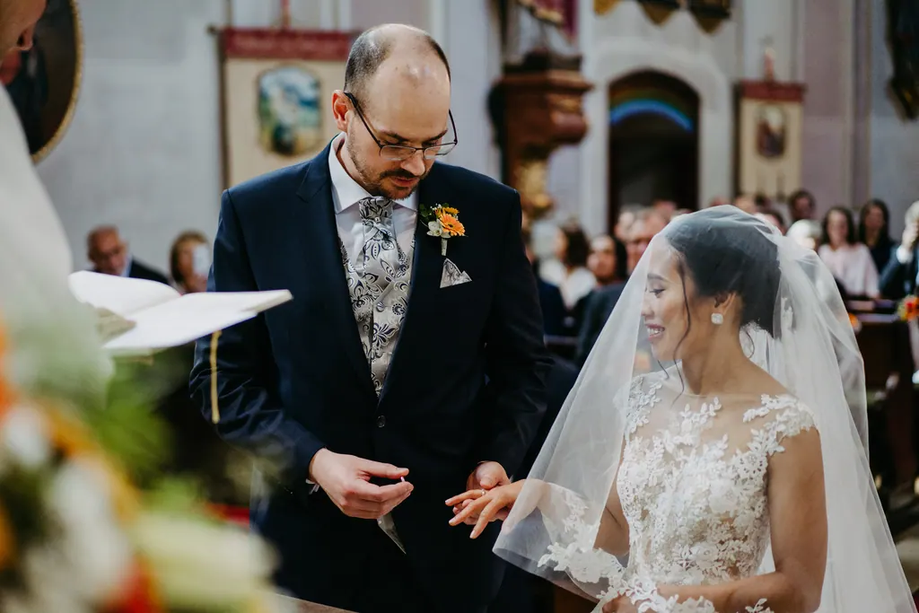 Bräutigam steckt der Braut am Altar den Ring an
