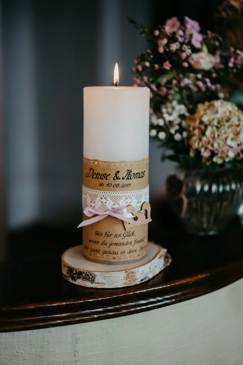 Brennende Hochzeitskerze mit Spitze und Blumen