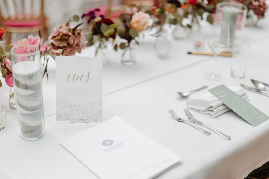 Gedeckte Hochzeitstafel mit Menükarte, Windlicht und Blumen in Pink