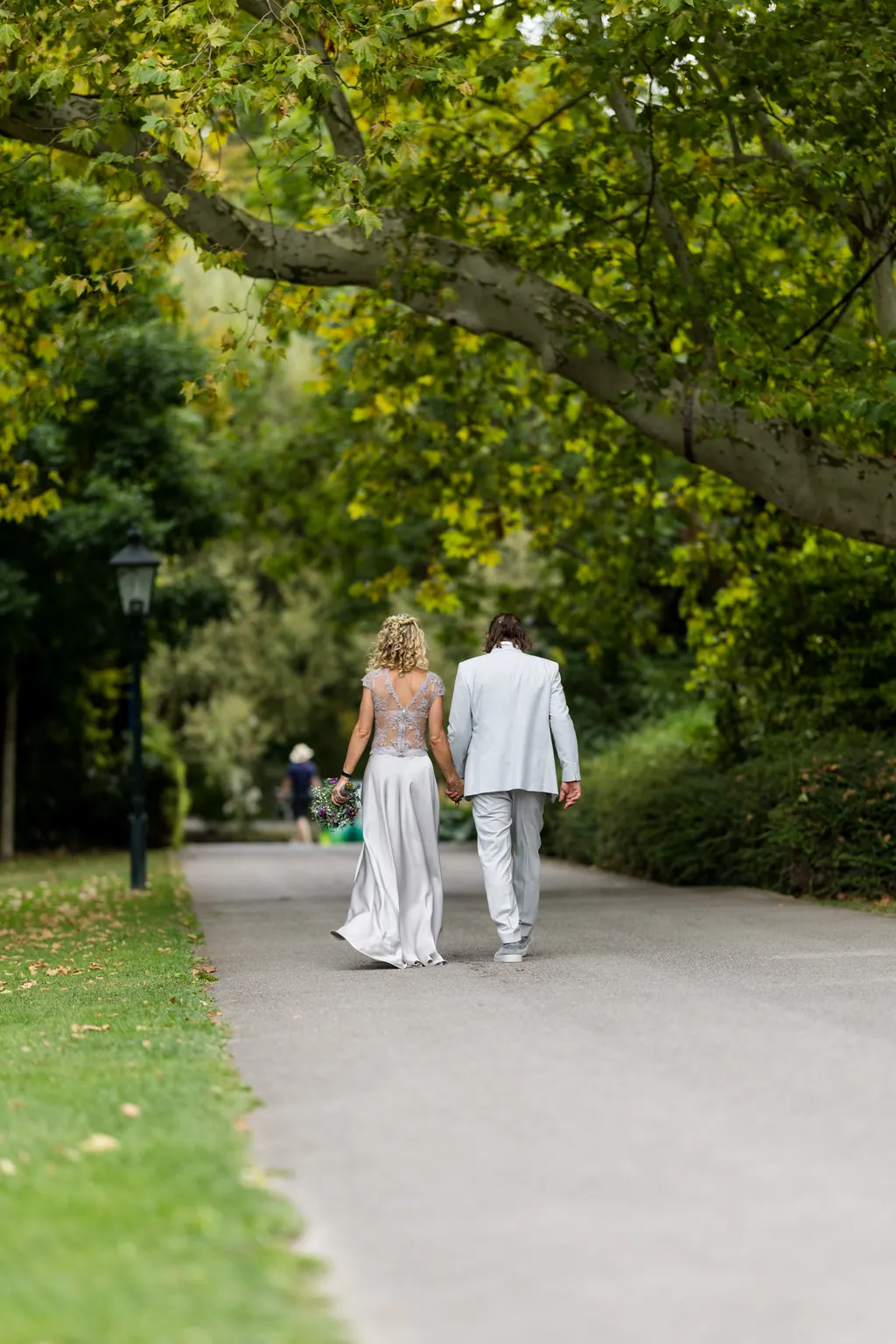 Braut sitzt am Morgen der Hochzeit im Sessel, daneben hängt das Brautkleid