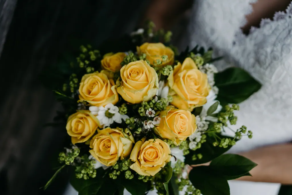 Brautstrauß aus gelben Rosen und weißen Blüten in Nahaufnahme