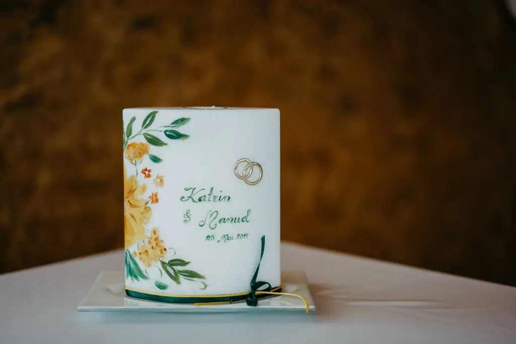 Bemalte Hochzeitskerze mit gelben Blumen und Ringmotiv