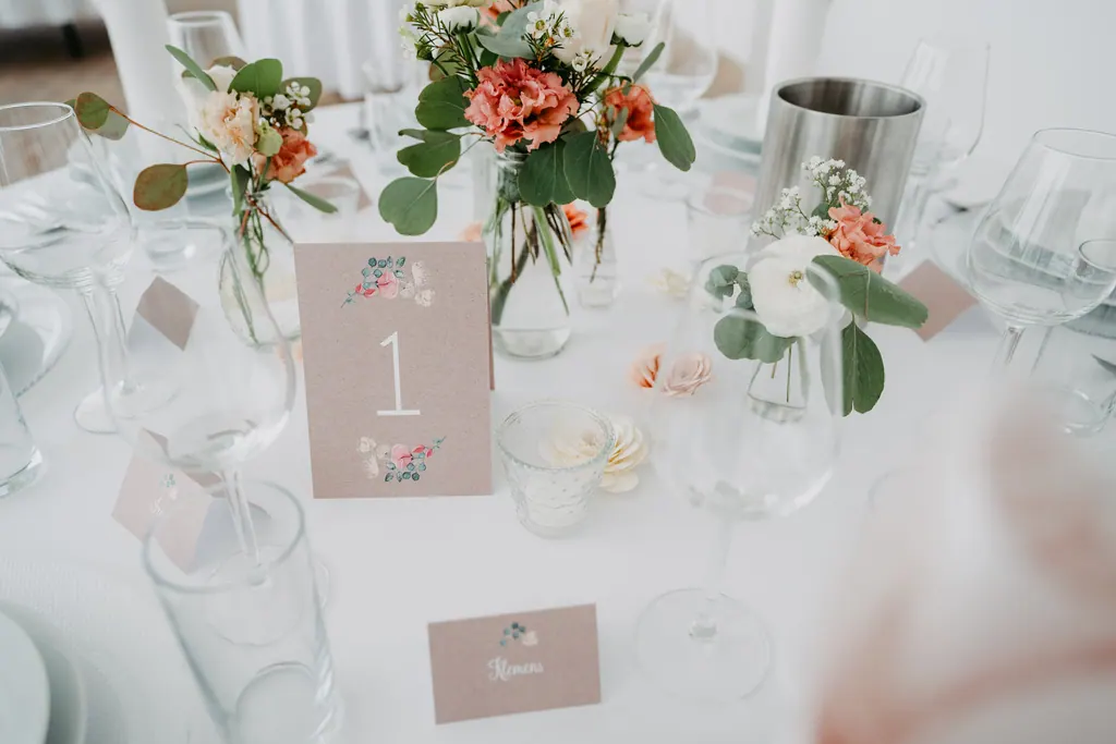 Gedeckte Hochzeitstafel mit Rosen in Apricot und Tischnummer