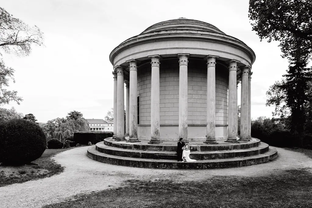 Leopoldinentempel im Schlosspark in Schwarzweiß, das Brautpaar klein auf den Stufen