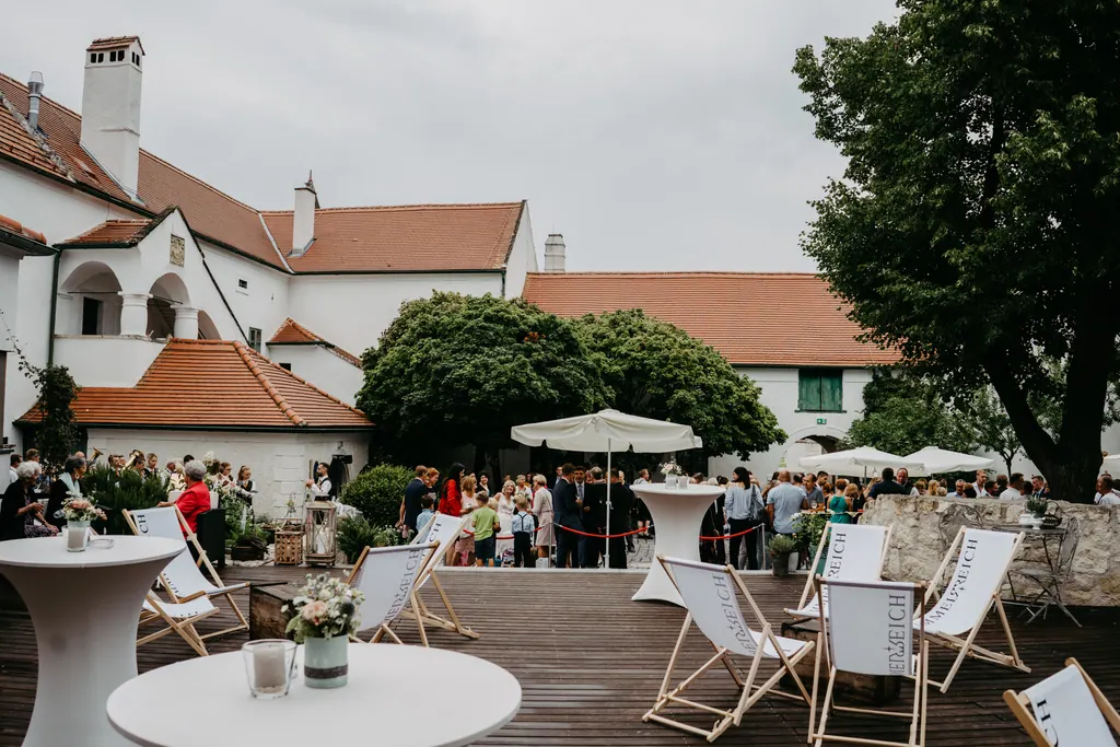 Innenhof des Martinsschlössls mit Liegestühlen, Stehtischen und Sonnenschirmen