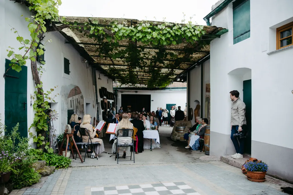 Innenhof unter einer Weinlaube, für die Trauung mit Stühlen bestuhlt