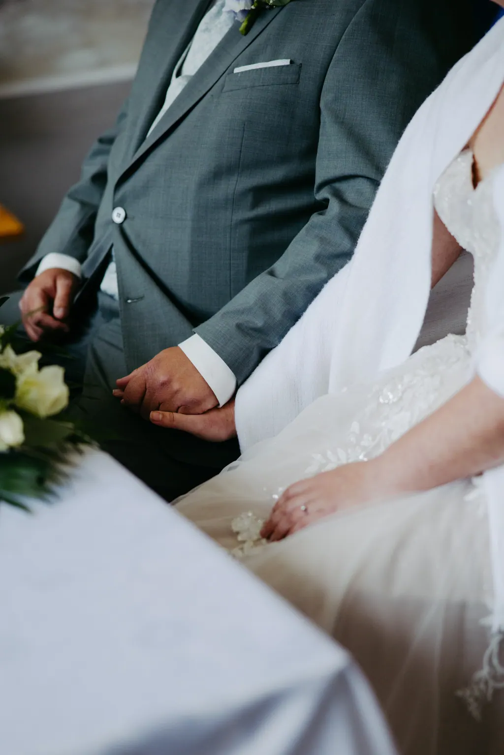 Hände des Brautpaars während der Trauung am Tisch
