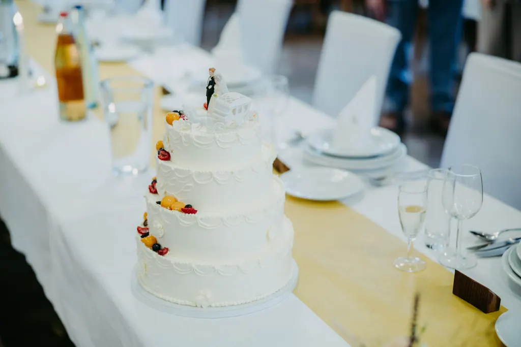 Weiße Hochzeitstorte mit Früchten auf der festlich gedeckten Tafel