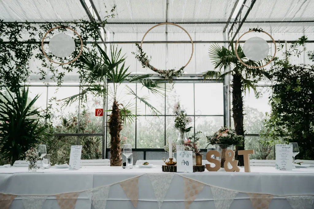 Brauttafel im Glashaus mit Palmen und Holzbuchstaben S & T