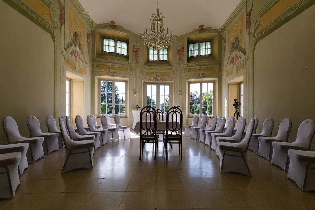 Festlich bestuhlter Saal der Orangerie mit Kronleuchter und Trautisch