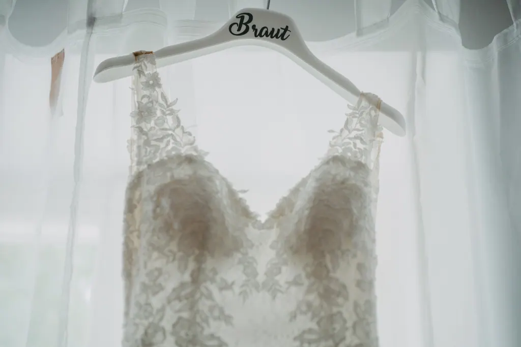 Spitzenbrautkleid auf einem Bügel mit der Aufschrift Braut